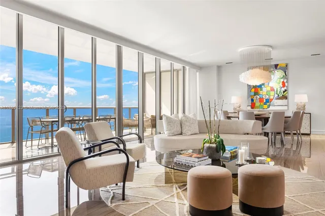 a living room with furniture and floor to ceiling windows