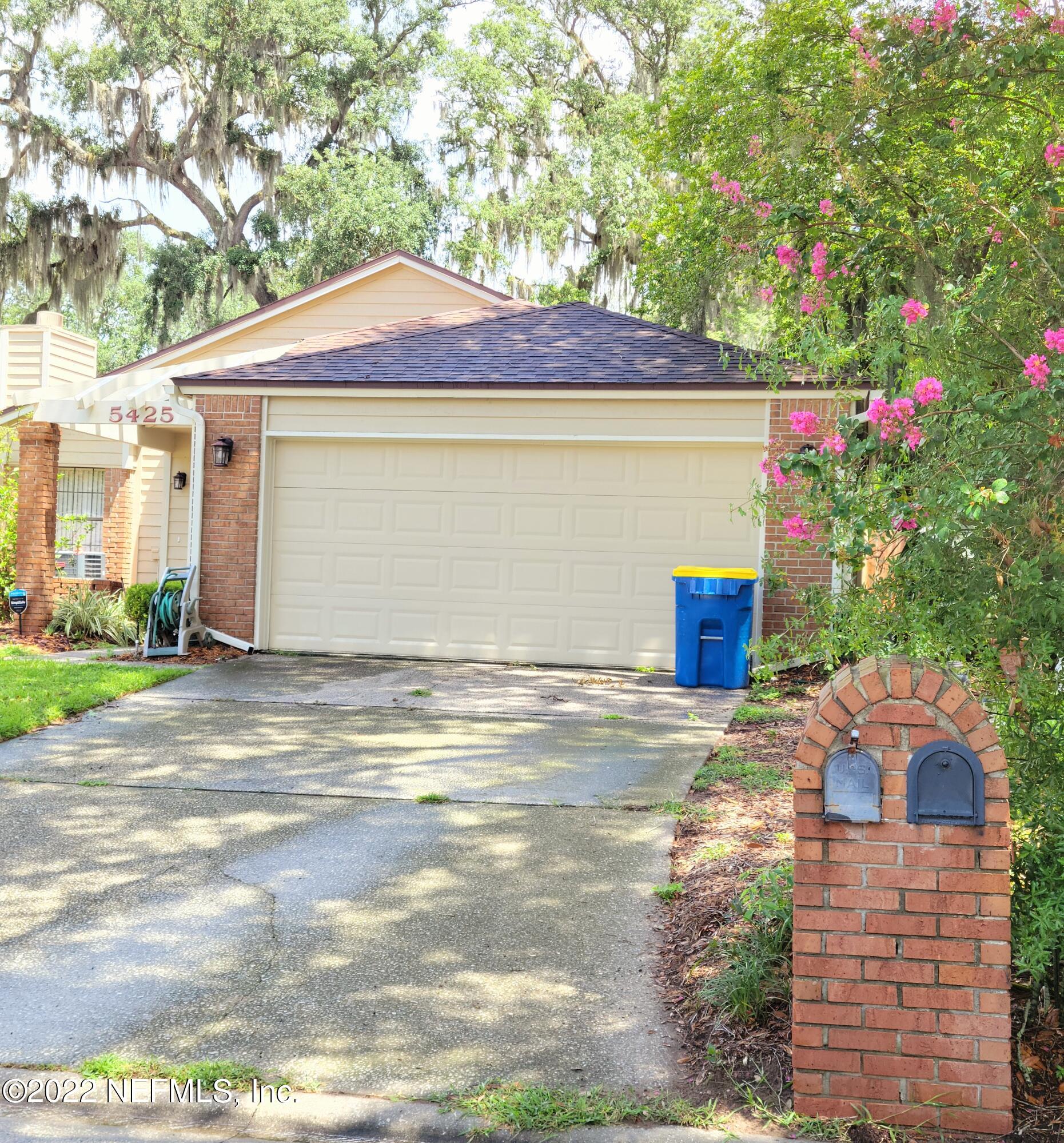 5425 Spring Brook Road Jacksonville, FL 32277 - Photo 2 of 35 a front view of a house with a yard and garage