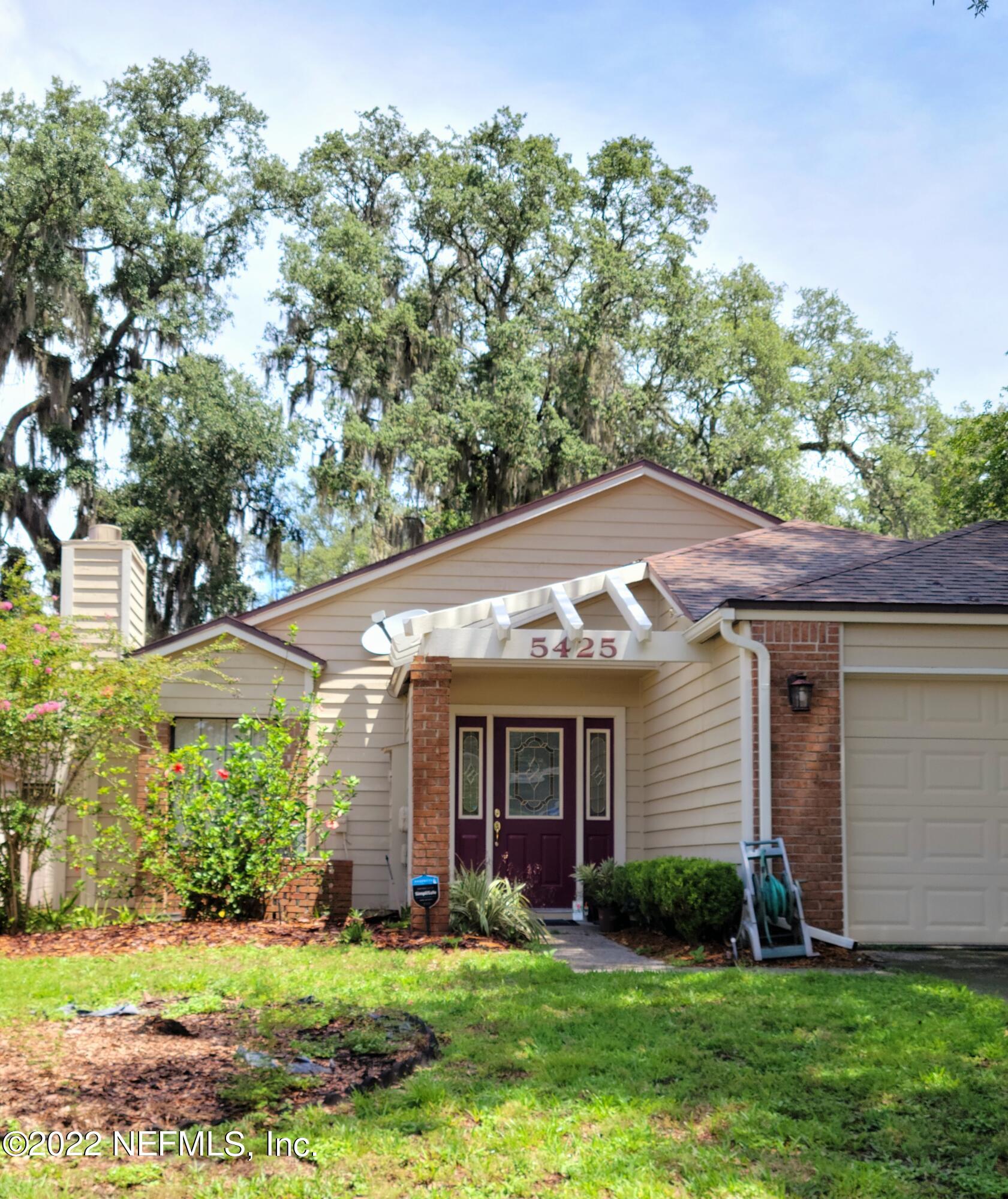 5425 Spring Brook Road Jacksonville, FL 32277 - Photo 3 of 35 a view of a yard in front of a house with plants and large tree