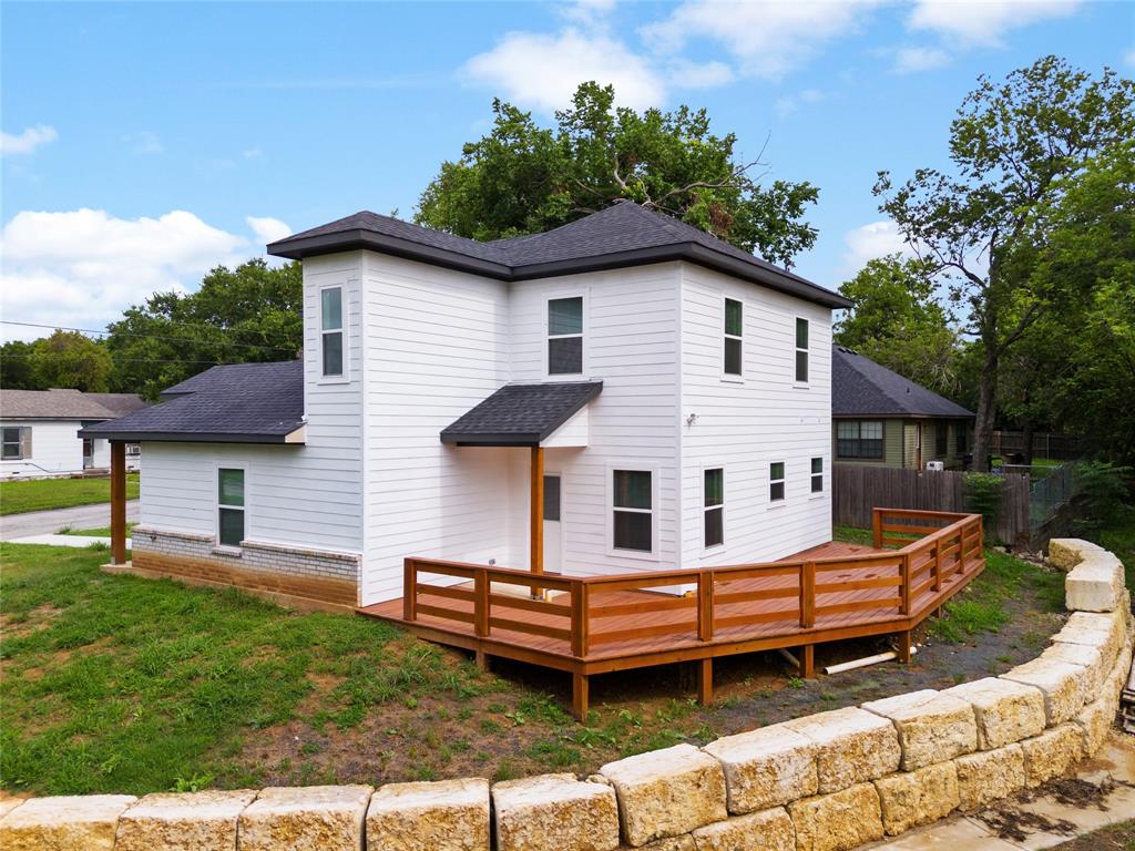709 South Church Street Decatur, TX 76234 - Photo 3 of 14 a white house that has a small yard and large trees