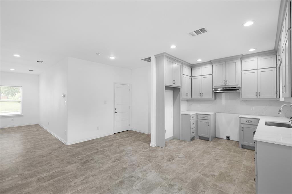 709 South Church Street Decatur, TX 76234 - Photo 6 of 14 a open kitchen with white cabinets and stainless steel appliances