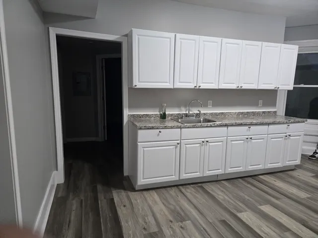 a kitchen with a sink window and cabinets