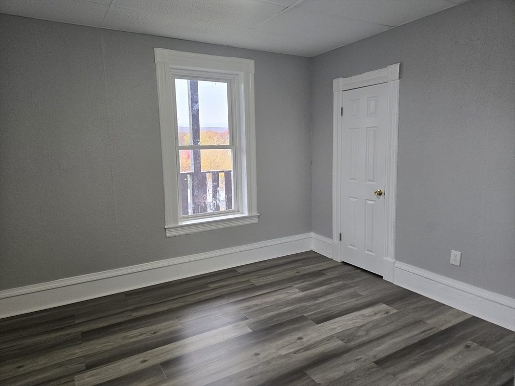 123 Walnut Street, Unit 4L Holyoke, MA 01040 - Photo 12 of 16 a view of an empty room with wooden floor and a window