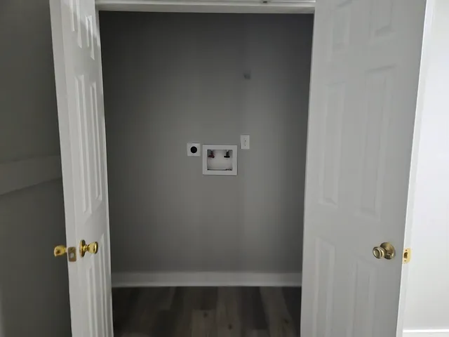 a view of an empty room with wooden floor and windows