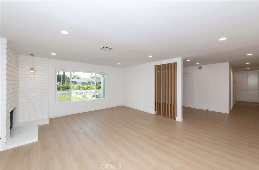 8665 Los Coyotes Drive Buena Park, CA 90621 - Photo 5 of 20 an empty room with large windows and a fireplace