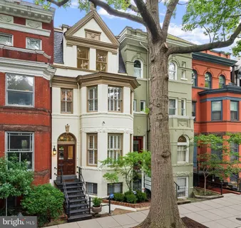 a living room with furniture fireplace and a large window