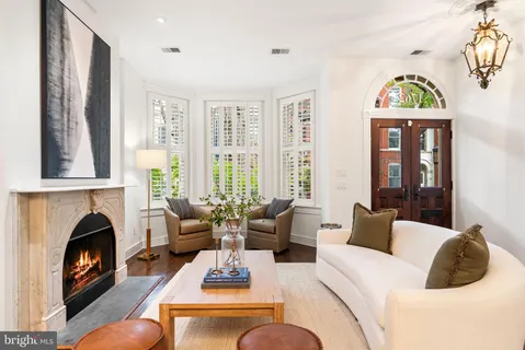 a living room with furniture a fireplace and a chandelier