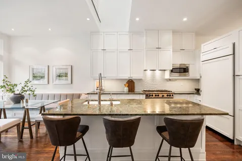 a kitchen with a stove a sink and wooden cabinets