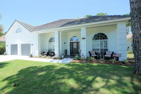 a view of a house with backyard and sitting area