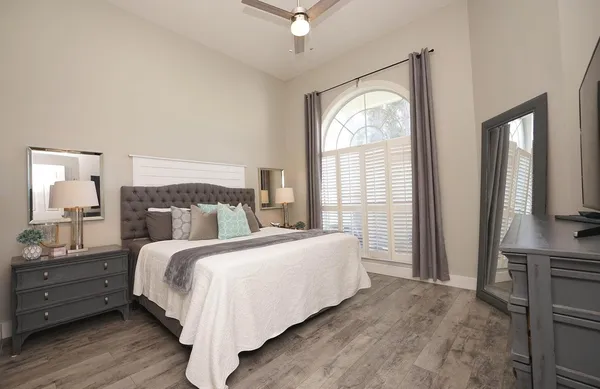 a bedroom with a bed and a large window