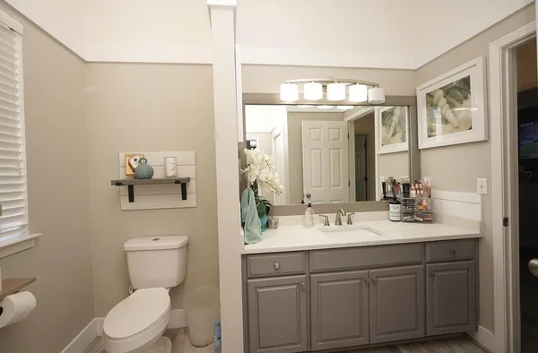 a bathroom with a sink vanity mirror and toilet