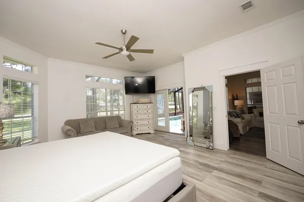 a bedroom with a large bed and wooden floor