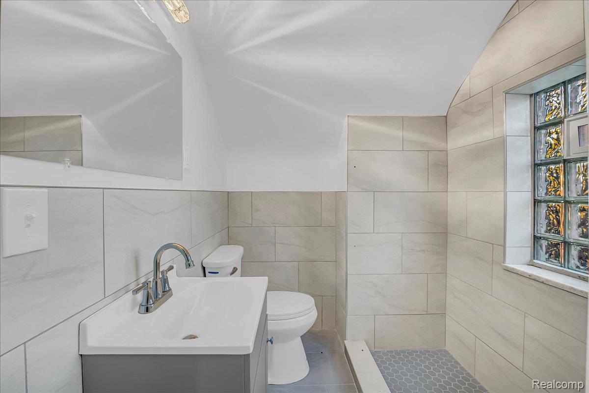 16717 Fielding Street Detroit, MI 48219 - Photo 37 of 46 Bathroom featuring tile walls, vanity, and a shower stall