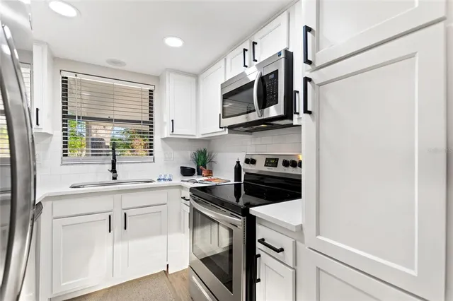 a kitchen with stainless steel appliances white cabinets and a sink
