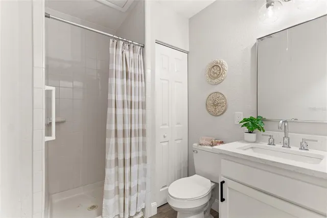 a bathroom with a sink a toilet a glass door shower and a mirror