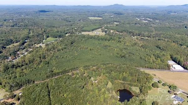 an aerial view of a house with yard and green space