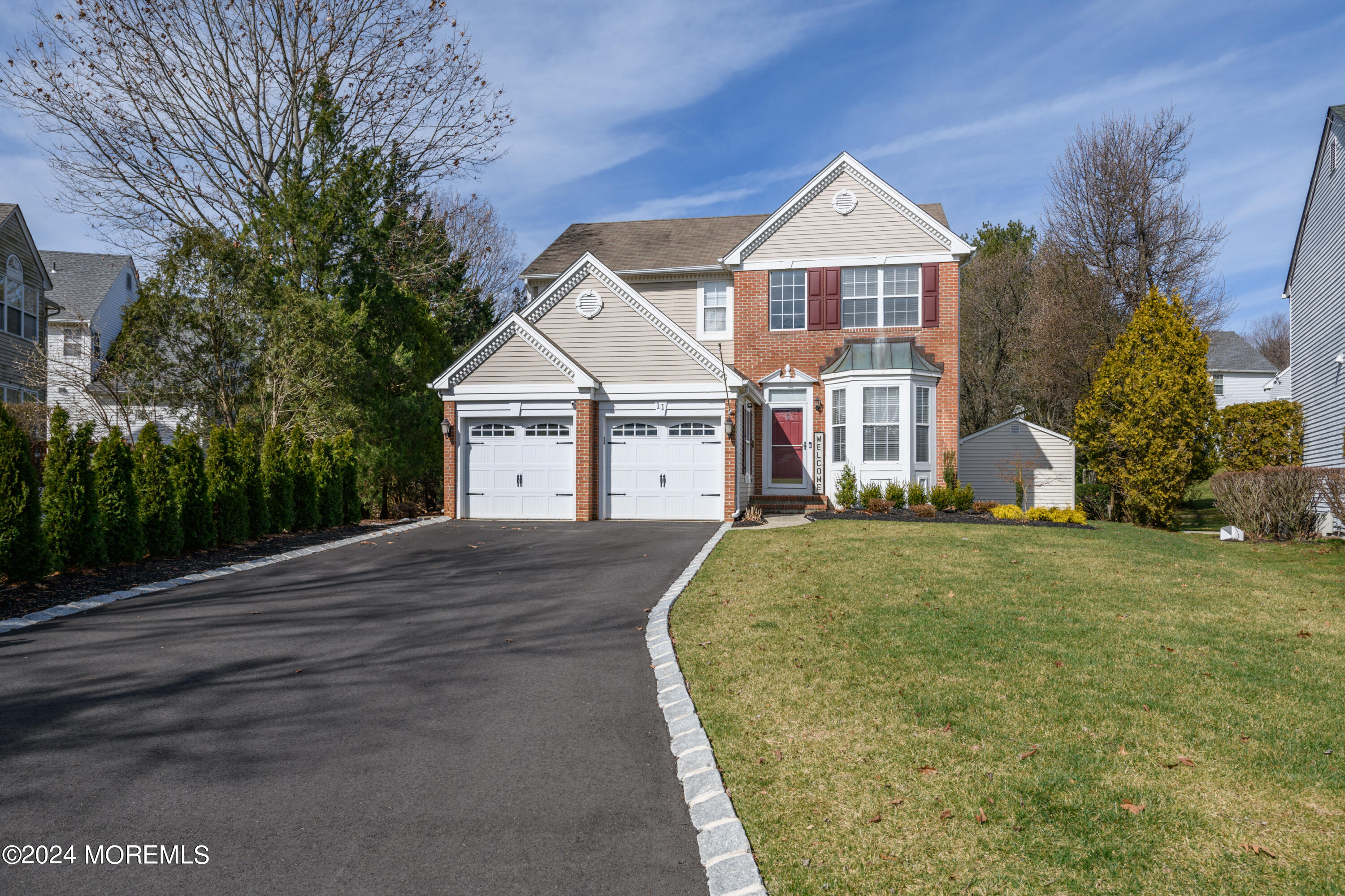 11 Exeter Pass Colts Neck, NJ 07722 - Photo 2 of 26 a front view of a house with a yard and garage