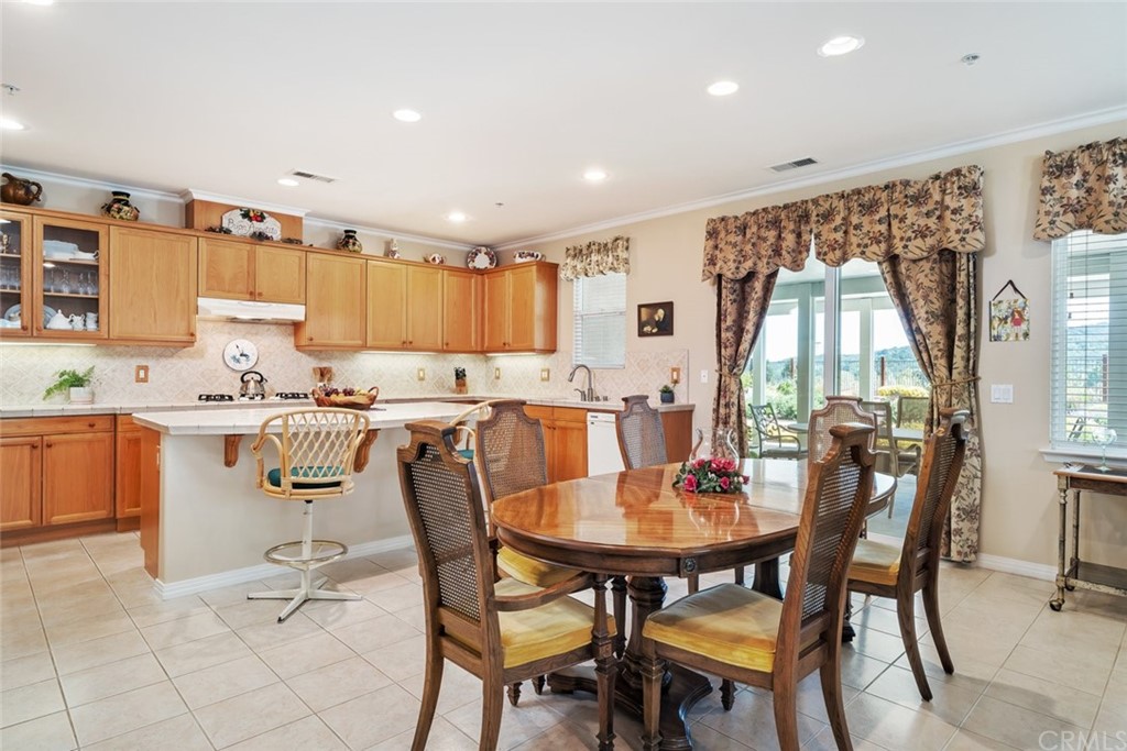 1675 Via Rojas Templeton, CA 93465 - Photo 8 of 60 a dining room with stainless steel appliances a table and chairs