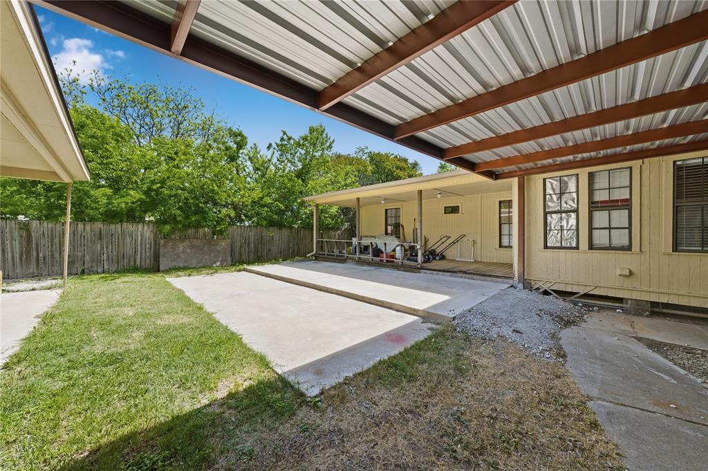 3624 Redbird Street Bellmead, TX 76705 - Photo 20 of 20 a view of a backyard with table and chairs under an umbrella with a small yard