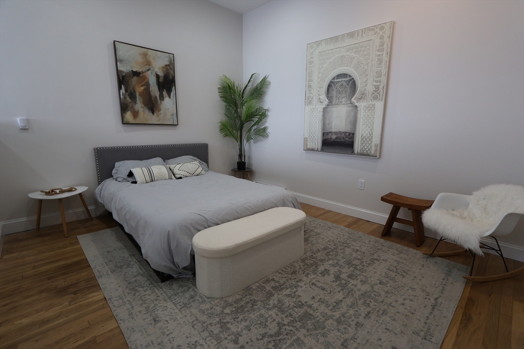 331 Proctor Avenue Revere, MA 02151 - Photo 21 of 29 a bedroom with a bed a painting on the wall and a potted plant