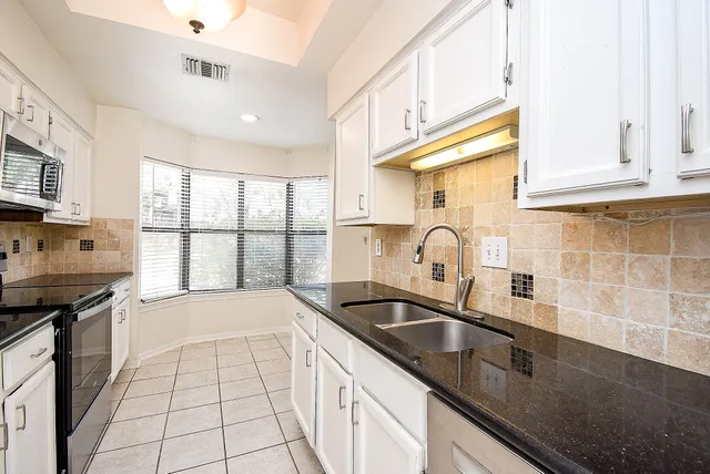 a kitchen with stainless steel appliances a sink a stove and a window
