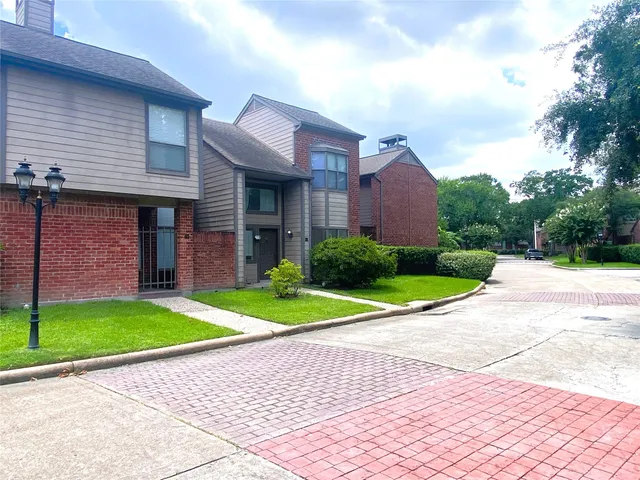 a view of a brick house with a yard