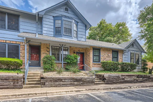 front view of a brick house with potted plants