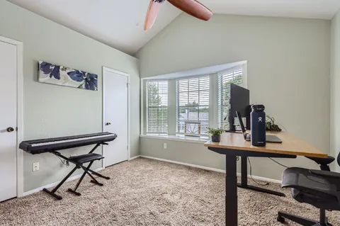 a view of a workspace with furniture and a window