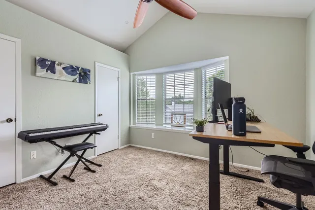 a view of a workspace with furniture and a window