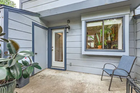 a view of a porch with a table and chairs and potted plants