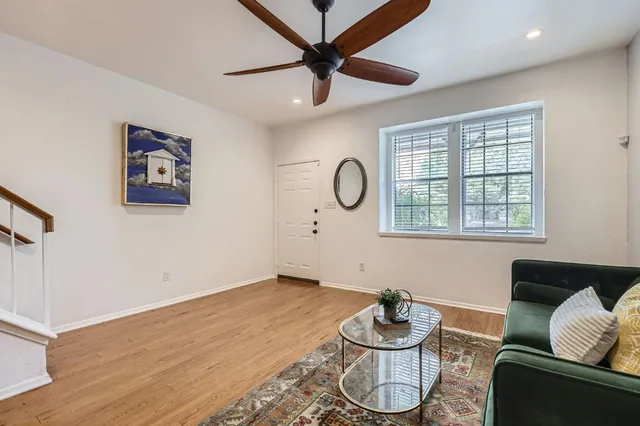 a living room with hard wood floor furniture and a window