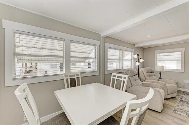 a kitchen with stainless steel appliances granite countertop a stove a refrigerator a sink a dining table and chairs