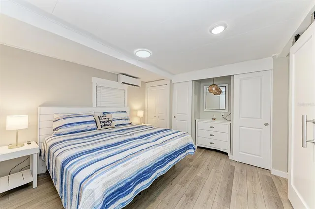 a view of a bedroom with wooden floor and closet
