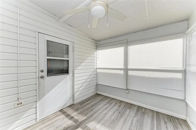 en empty room with wooden floor and windows