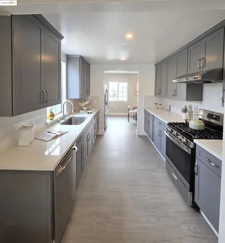 a large kitchen with stainless steel appliances lots of counter space and wooden floor