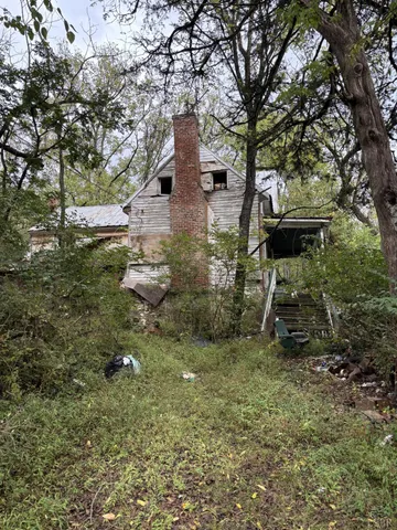 a backyard of a house with table and chairs