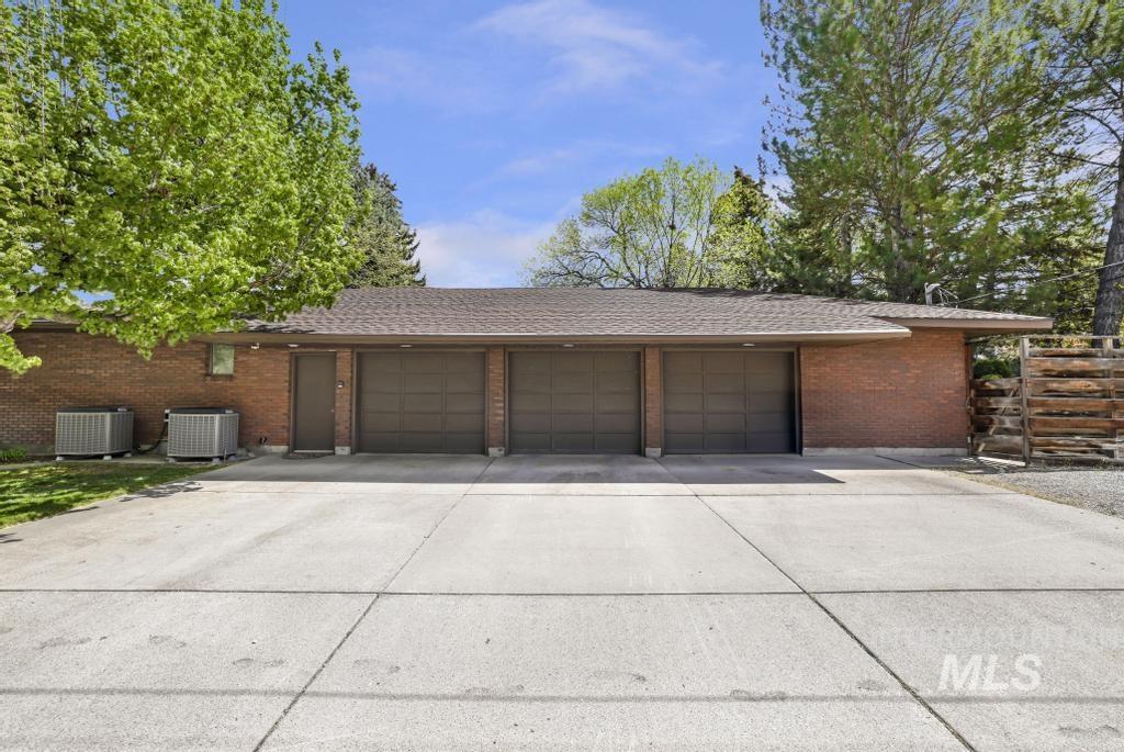 2018 Rancho Vista Drive Twin Falls, ID 83301 - Photo 6 of 50 Three-car garage with individual doors, brick exterior, and a concrete driveway