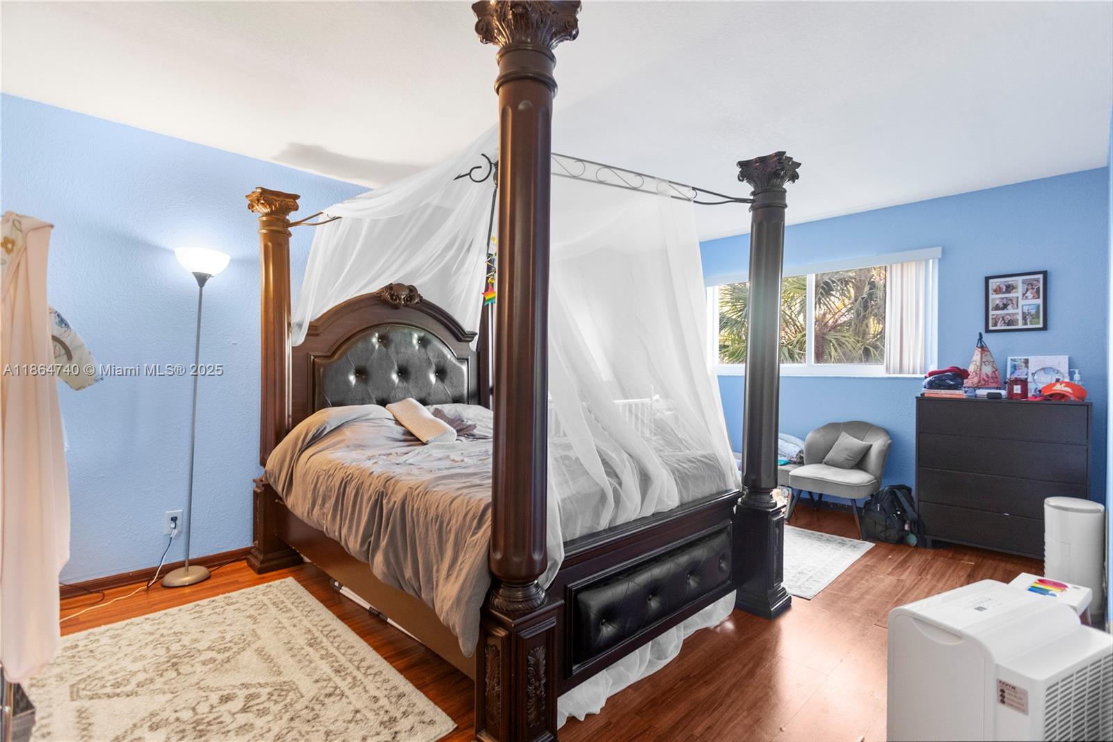 701 Northeast 1st Court, Unit 209 Hallandale Beach, FL 33009 - Photo 30 of 39 a bedroom with a bed and wooden floor