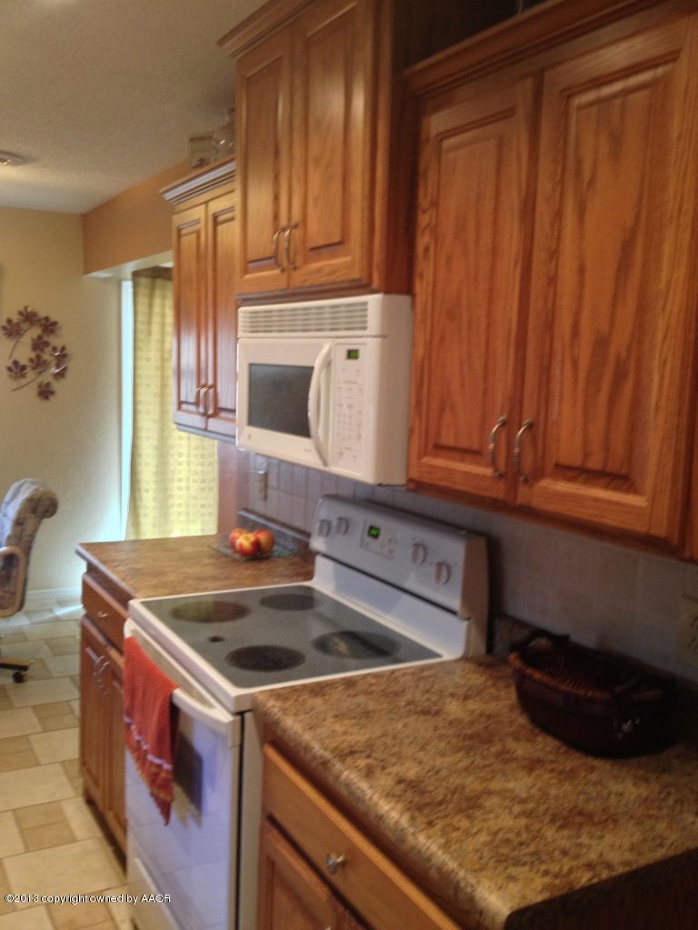 8213 Goodnight Trail Amarillo, TX 79110 - Photo 11 of 20 a kitchen with granite countertop a sink stove and cabinets