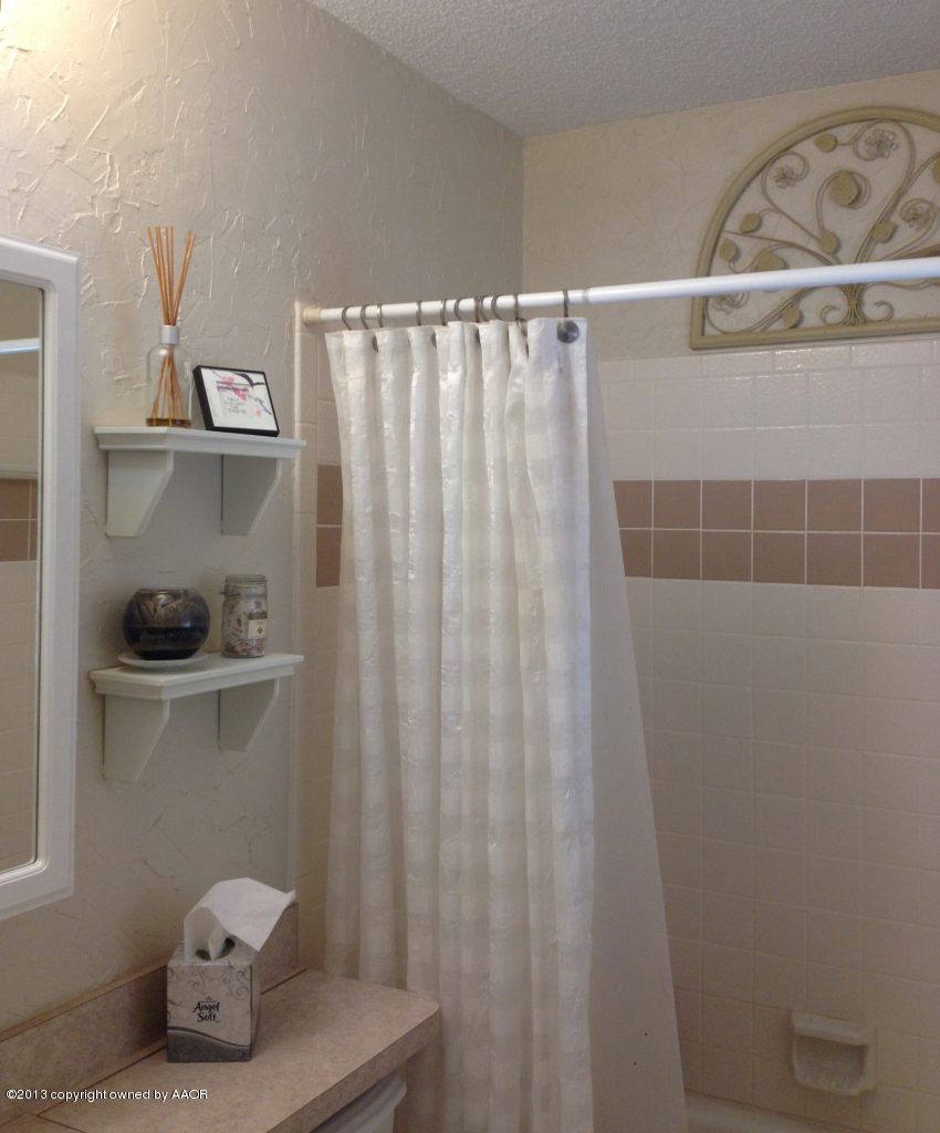 8213 Goodnight Trail Amarillo, TX 79110 - Photo 16 of 20 a bathroom with a shower curtain and a sink