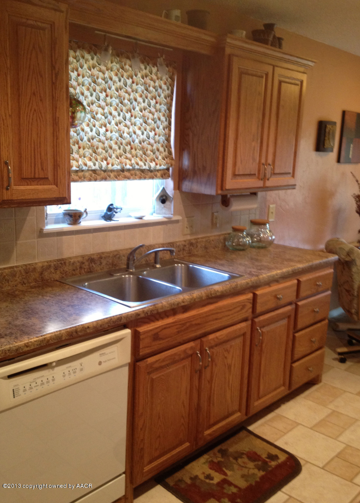 8213 Goodnight Trail Amarillo, TX 79110 - Photo 10 of 20 a kitchen with stainless steel appliances granite countertop a sink stove and cabinets