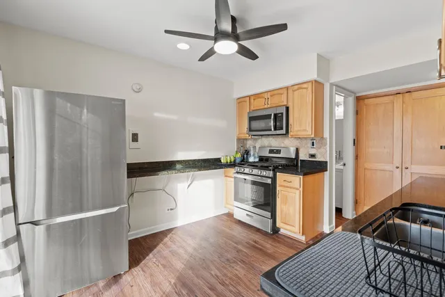 a kitchen with granite countertop a refrigerator stove top oven and sink