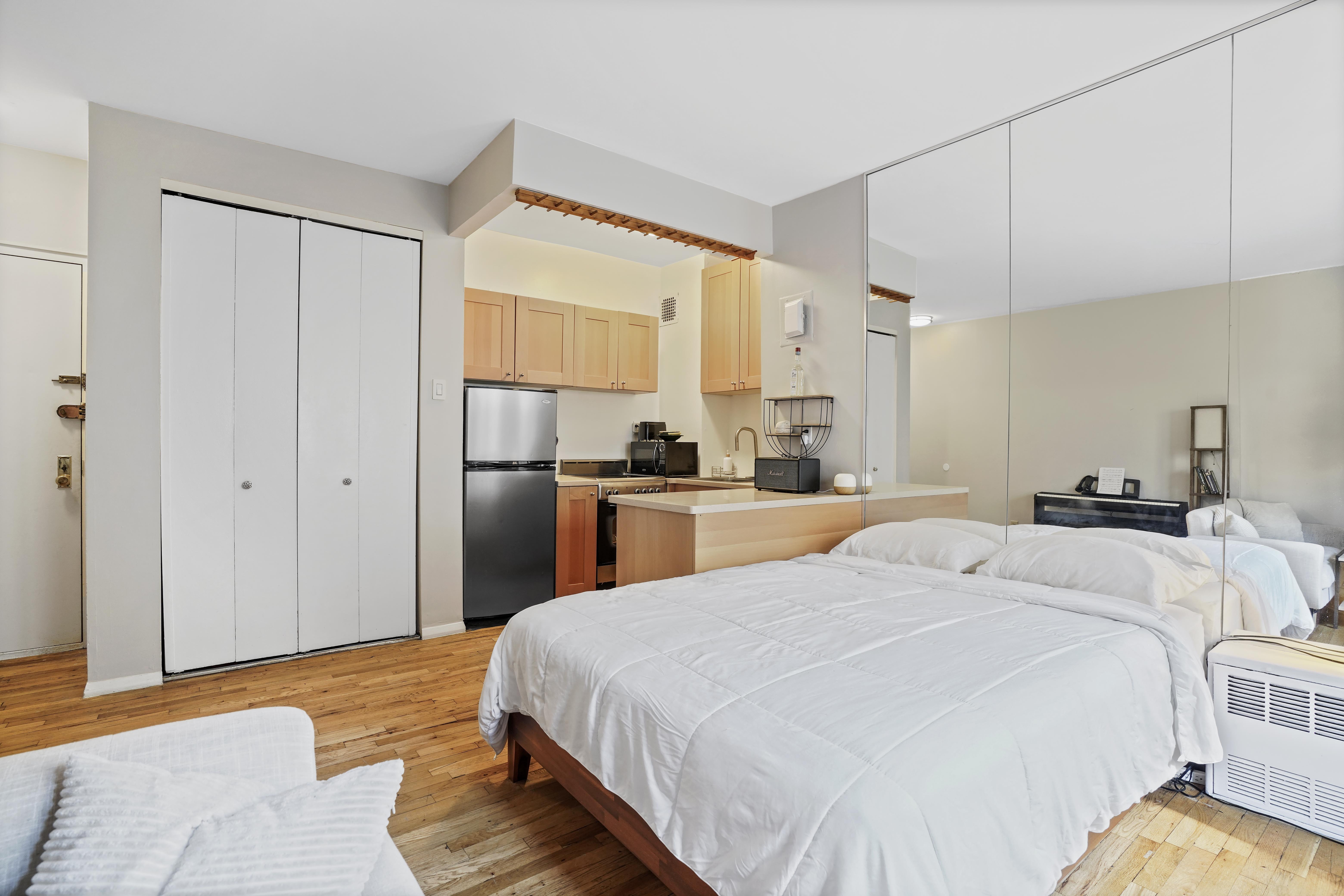 160 East 91st Street, Unit 7B Manhattan, NY 10128 - Photo 2 of 6 a bedroom with a bed and a refrigerator