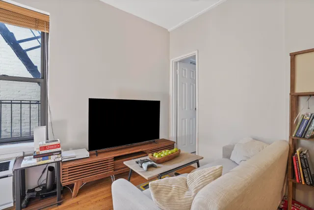 a bedroom with a bed and a refrigerator