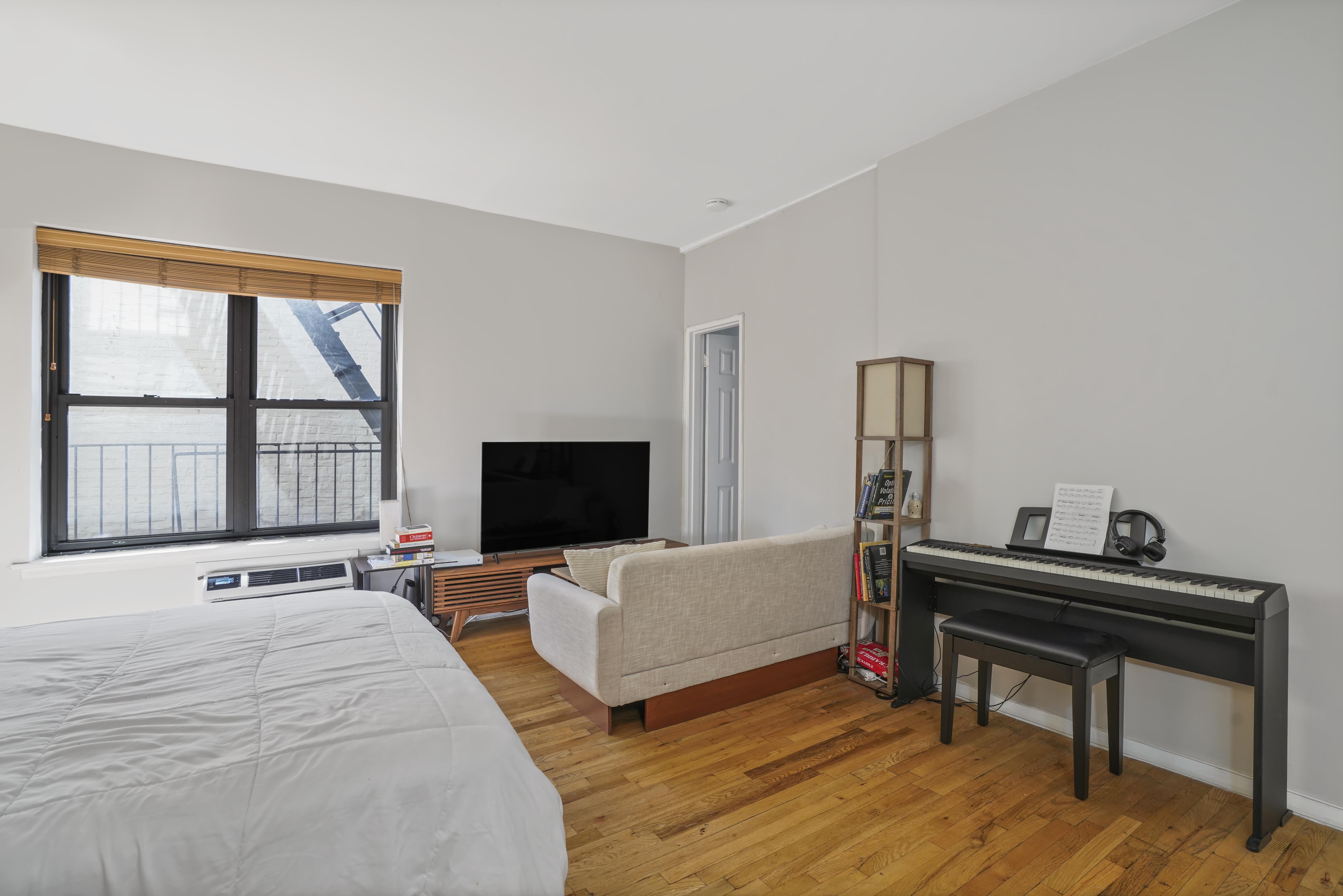160 East 91st Street, Unit 7B Manhattan, NY 10128 - Photo 4 of 6 a bedroom with furniture and a window