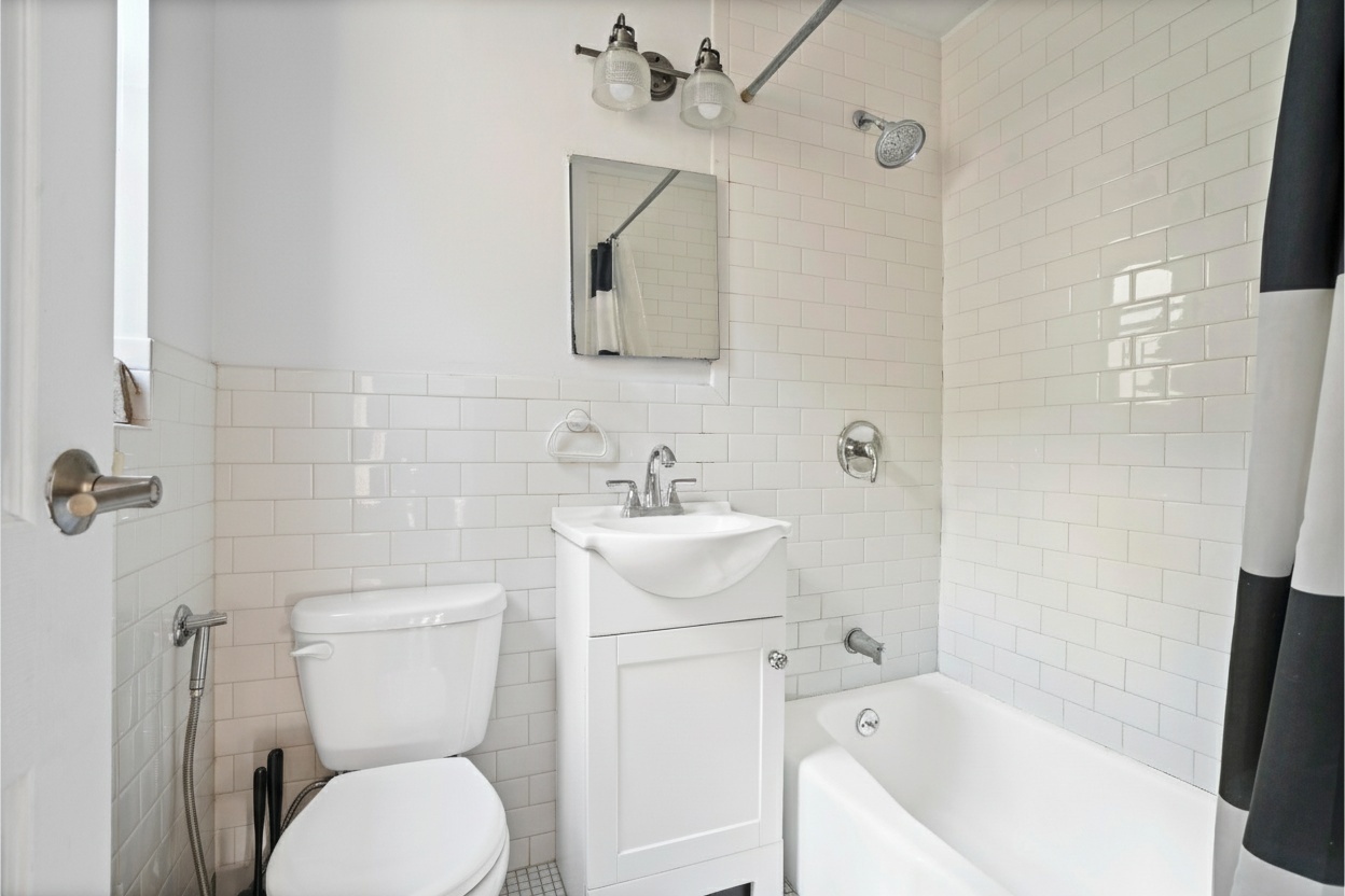 160 East 91st Street, Unit 7B Manhattan, NY 10128 - Photo 5 of 6 a bathroom with a sink toilet and shower
