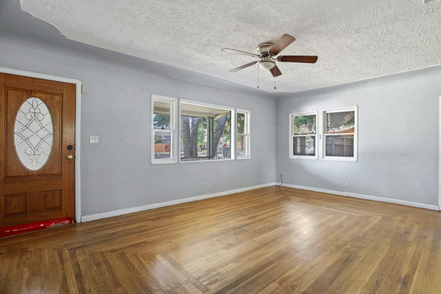 916 Elm Avenue Modesto, CA 95351 - Photo 10 of 52 11. Living room with front door and windows Original hardwood floors, classic front windows, and a warm wood entry door give this room that “they don’t build them like this anymore” feeling.
