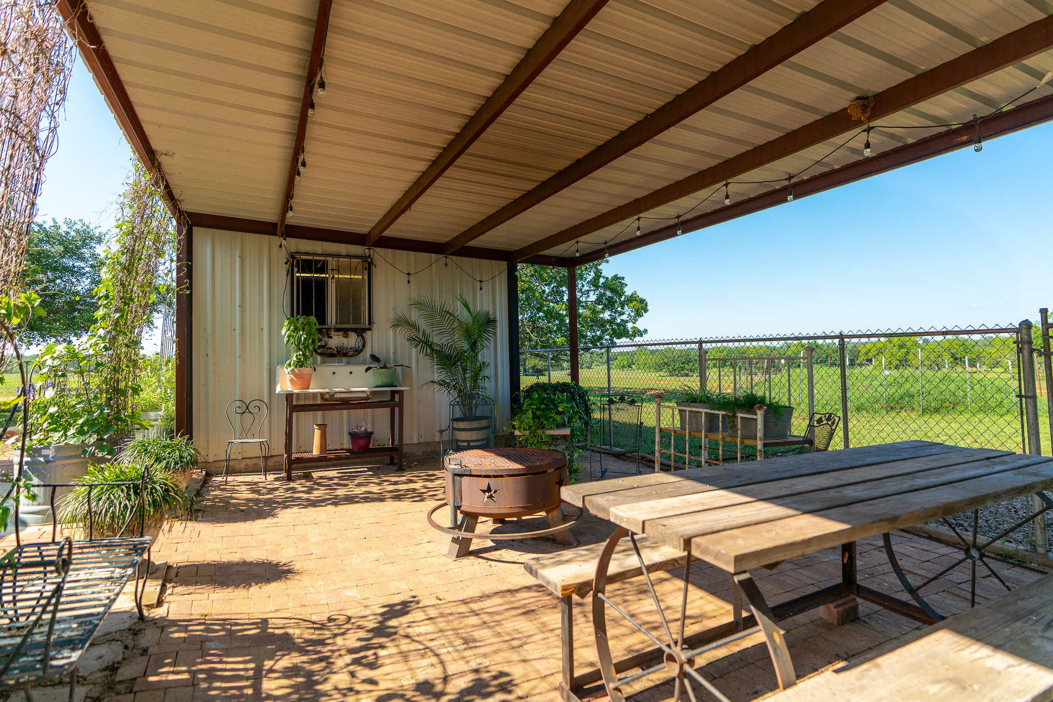 400 619th Spur Elgin, TX 78621 - Photo 31 of 40 An inviting covered patio with brick pavers offers a rustic retreat and sweeping views of the surrounding landscape.