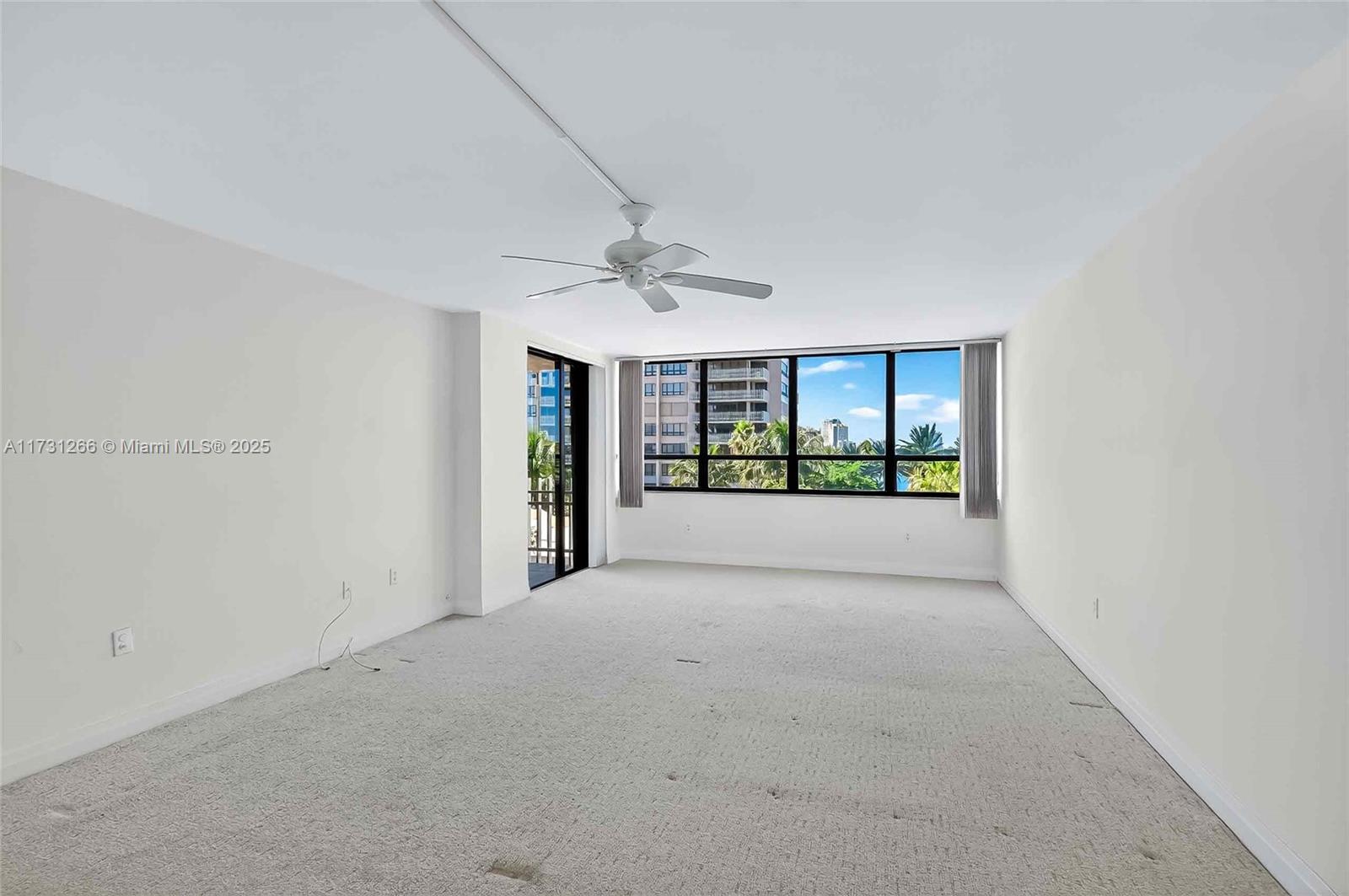 2 Grove Isle Drive, Unit B404 Coconut Grove, FL 33133 - Photo 21 of 36 a view of a big room with windows and chandelier fan