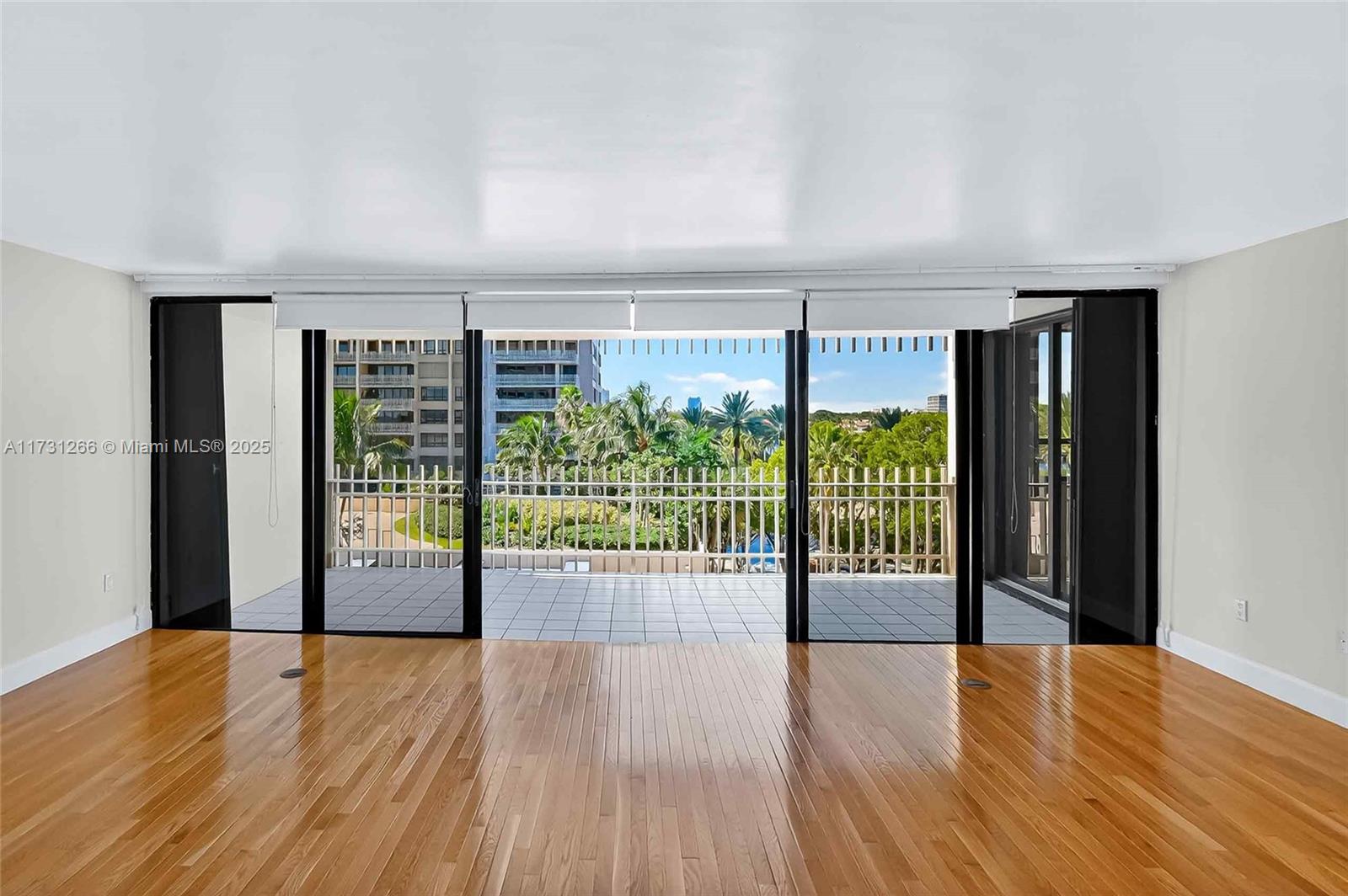 2 Grove Isle Drive, Unit B404 Coconut Grove, FL 33133 - Photo 5 of 36 a view of an empty room with wooden floor and a window